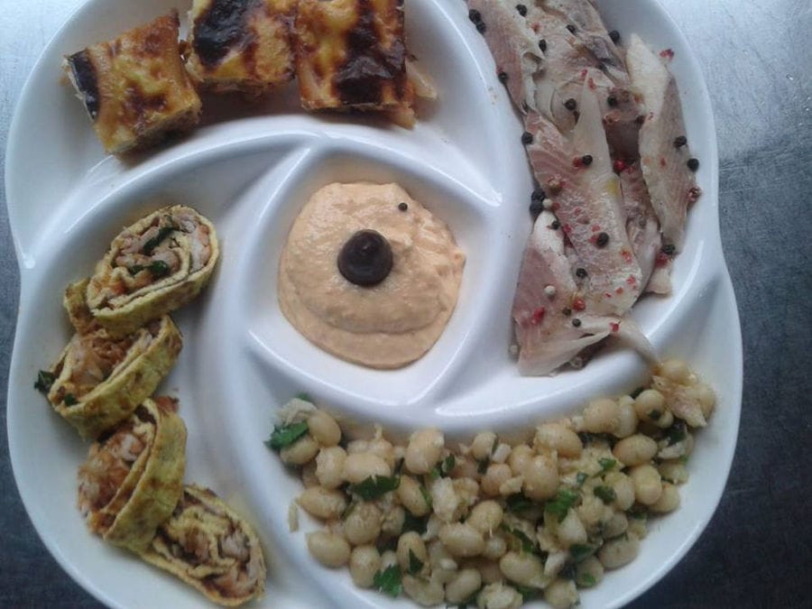 view from above of plate with spreads, pasta, marinated trout fillets, beans, omelette roll with smoked trout and pastitsio at 'Fresko'